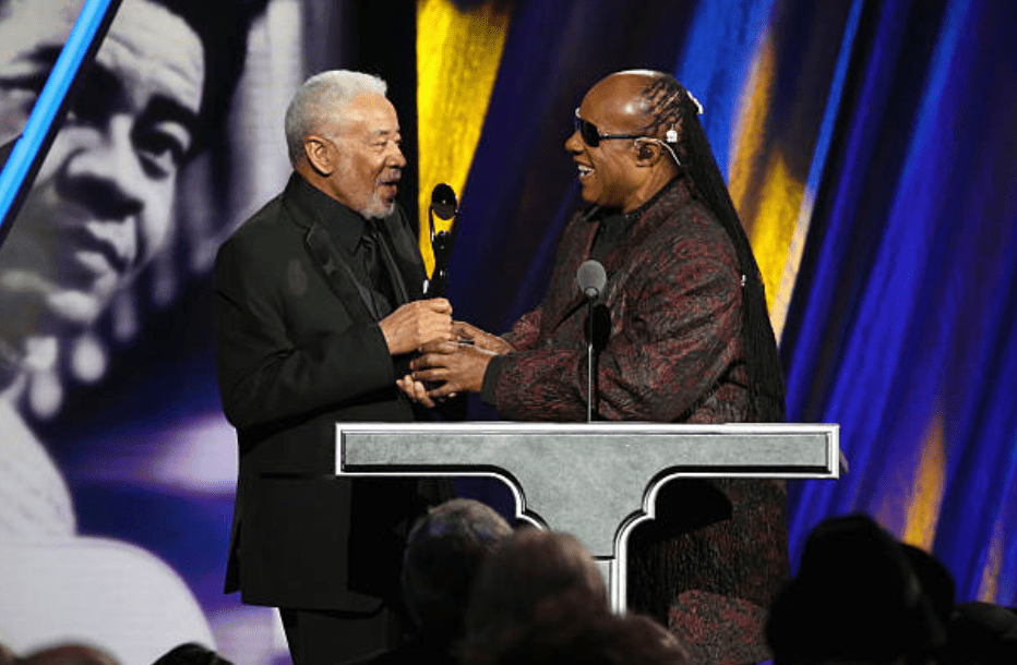 Stevie Wonder hand an award to Bill Withers during the ceremony at the 30th Rock And Roll Hall Of Fame Induction Ceremony on April 18, 2015, in Cleveland, Ohio | Source: Getty Images (Photo by Kevin Kane/WireImage for Rock and Roll Hall of Fame)