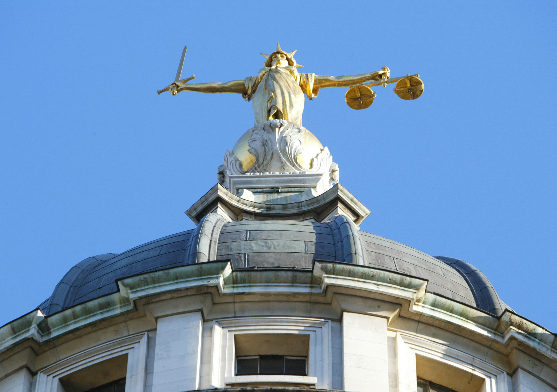 The statue of justice stands on the cupola of the Old Bailey courthouse photographed after Ian Huntley was sentenced to two life terms in prison for murdering 10-year-old school girls Holly Wells and Jessica Chapman and his girlfriend, Maxine Carr, was convicted of preventing the course of justice on December 17, 2003 in London, England. | Source: Getty Images