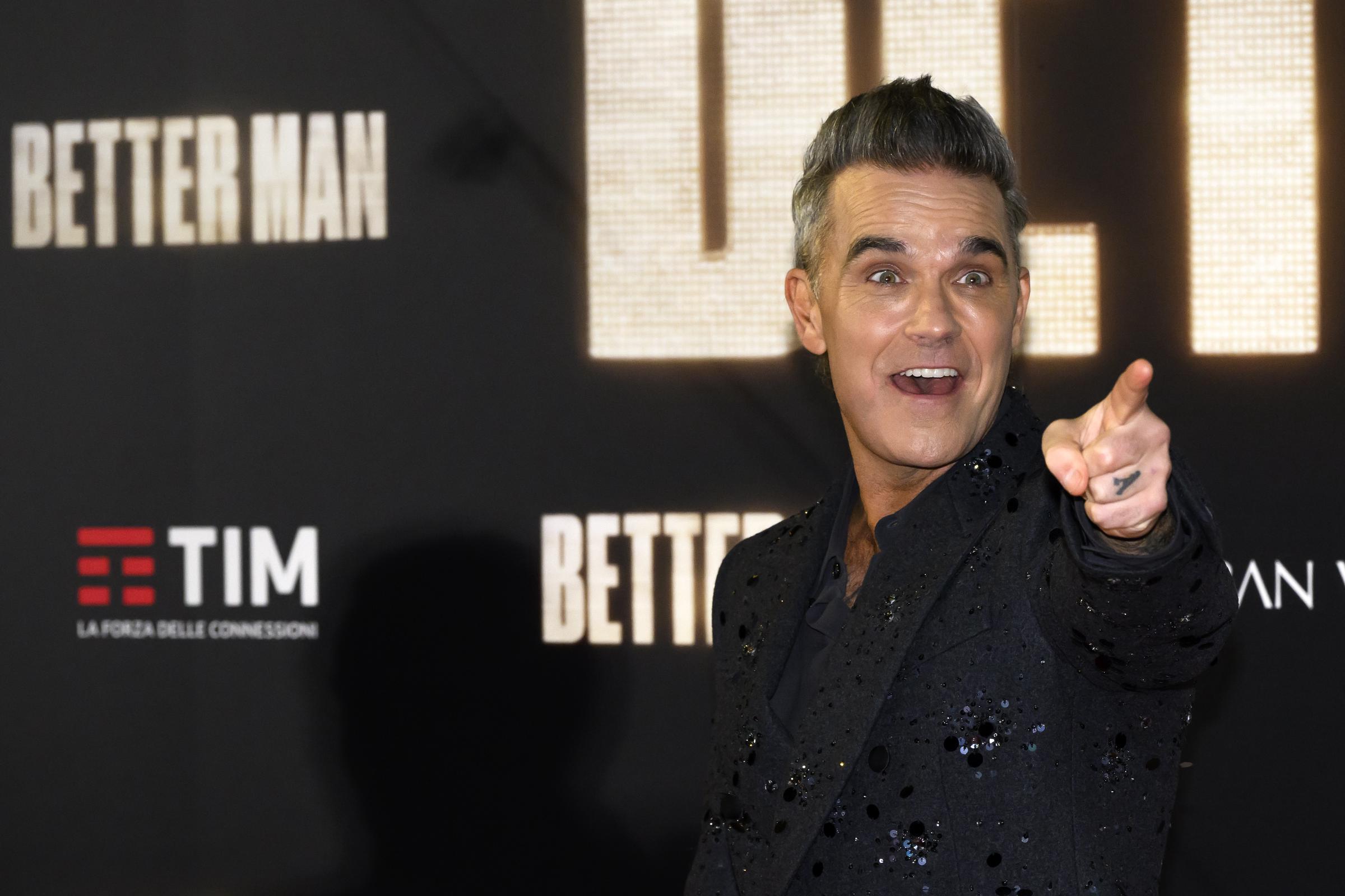 Robbie Williams appeared on the red carpet for the film "Better Man" on December 6, 2024, in Rome, Italy. Flashing a playful smile and pointing at cameras, he lit up the premiere in a sparkled suit that matched the occasion's star power.