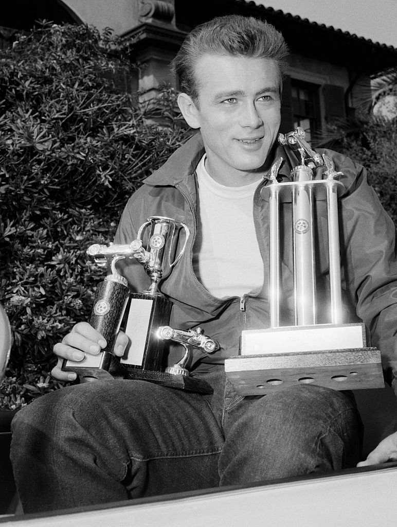 Schauspieler James Dean hält stolz die drei Trophäen, die er beim Palm Springs Road Race gewonnen hat. | Quelle: Getty Images