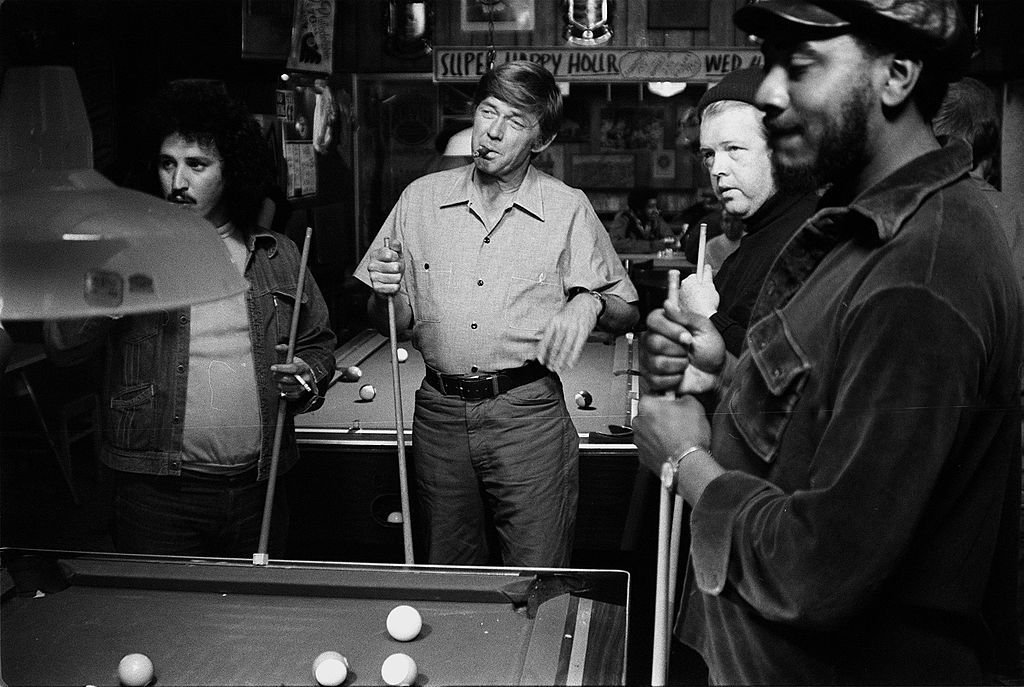 Ralph Waite smokes a cigar and enjoys a game of pool with his buddies in a scene from the movie "The Secret Life of John Chapman," circa 1976 | Photo: CBS Photo Archive/Getty Images