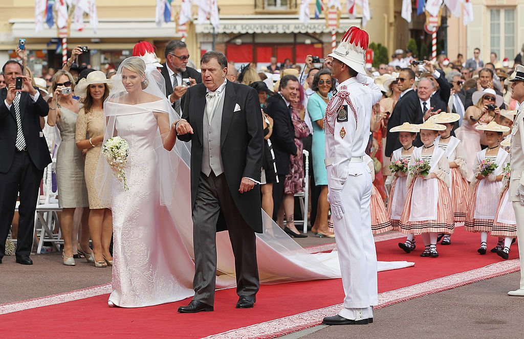 La princesse Charlene de Monaco est accompagnée de son père Michael Kenneth Wittstock lors de la cérémonie religieuse du mariage royal du prince Albert II de Monaco avec Charlene Wittstock dans la cour principale du Palais Princier le 2 juillet 2011 à Monaco, Monaco .| Photo : Getty Images
