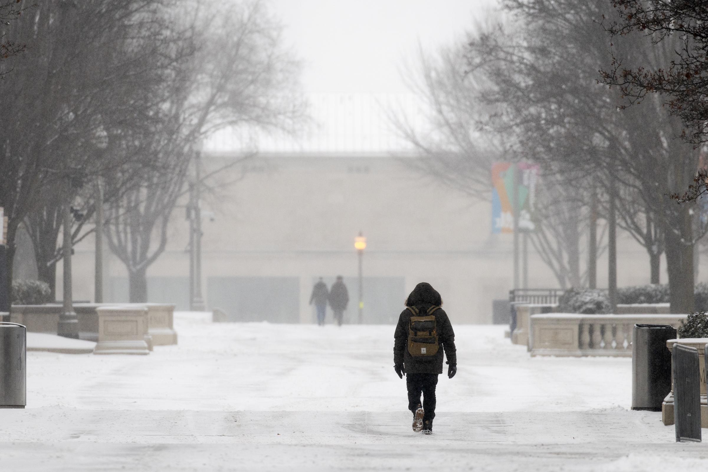 People walk along a snow-covered walkway on February 12, 2025, in Chicago, Illinois. | Source: Getty Images