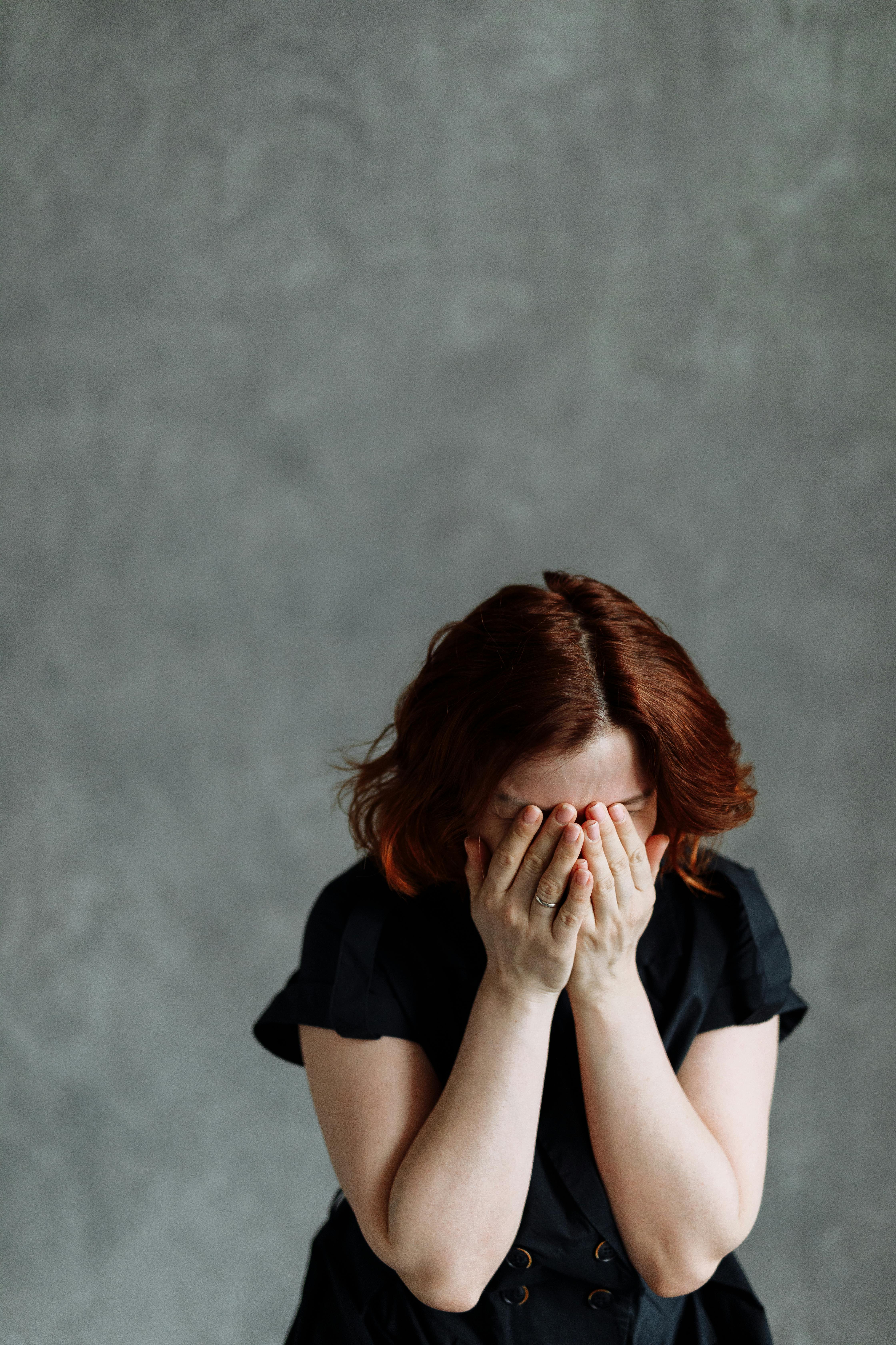 A woman covering her face with her hands | Source: Pexels