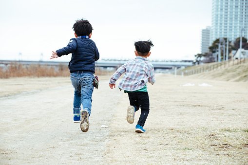 Photo of two young boys running across a field | Photo: Getty Images