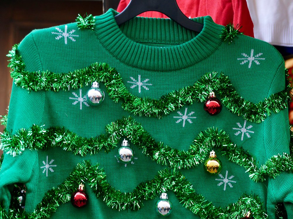 Un feo suéter navideño de color verde adornado con guirnaldas. | Foto: Shutterstock