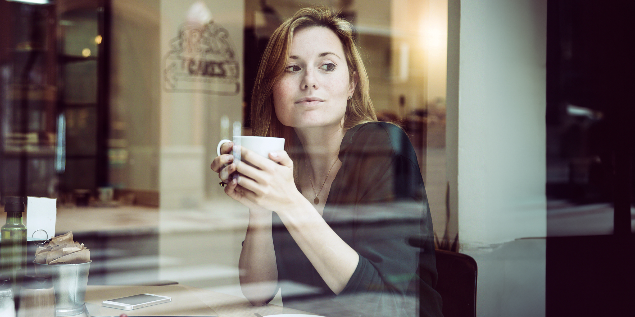 A woman sitting in a cafe | Source: freepik.com/freepik