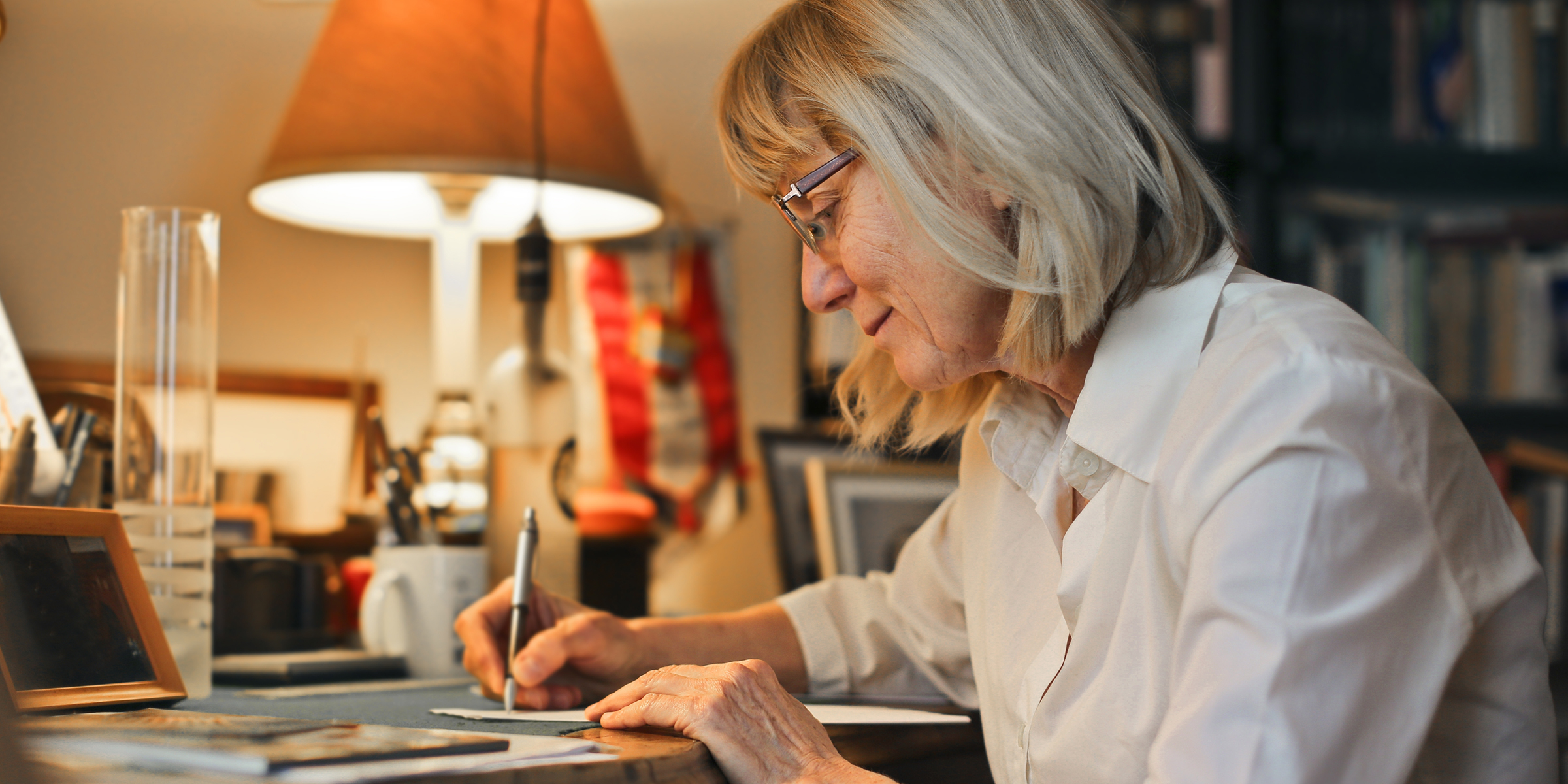 An elderly woman writing a letter | Source: Shutterstock