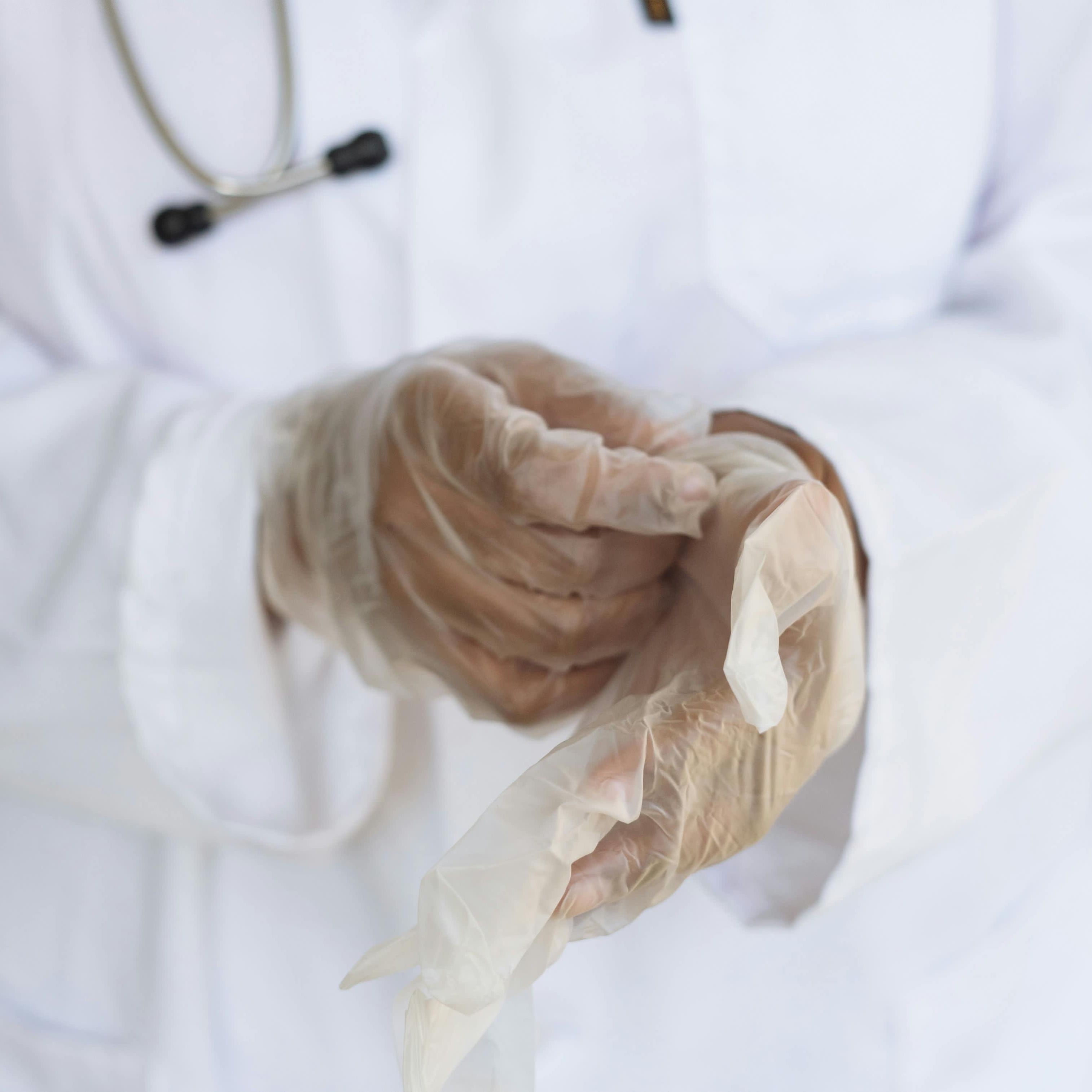 A medical professional pulling on latex gloves | Source: Pexels