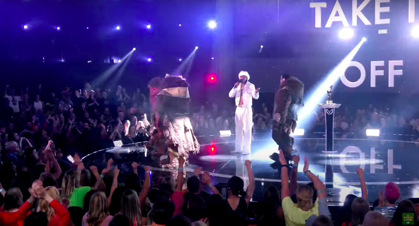 The crowd chanting "Boyz II Men!" with the finalists and Nick Cannon on the stage. | Source: YouTube/The Masked Singer