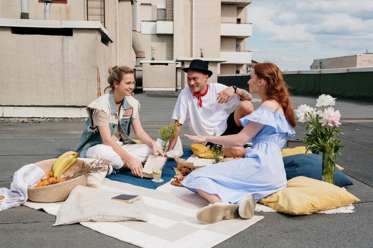 Three friends having a rooftop picnic. | Source: Pexels/cottonbro