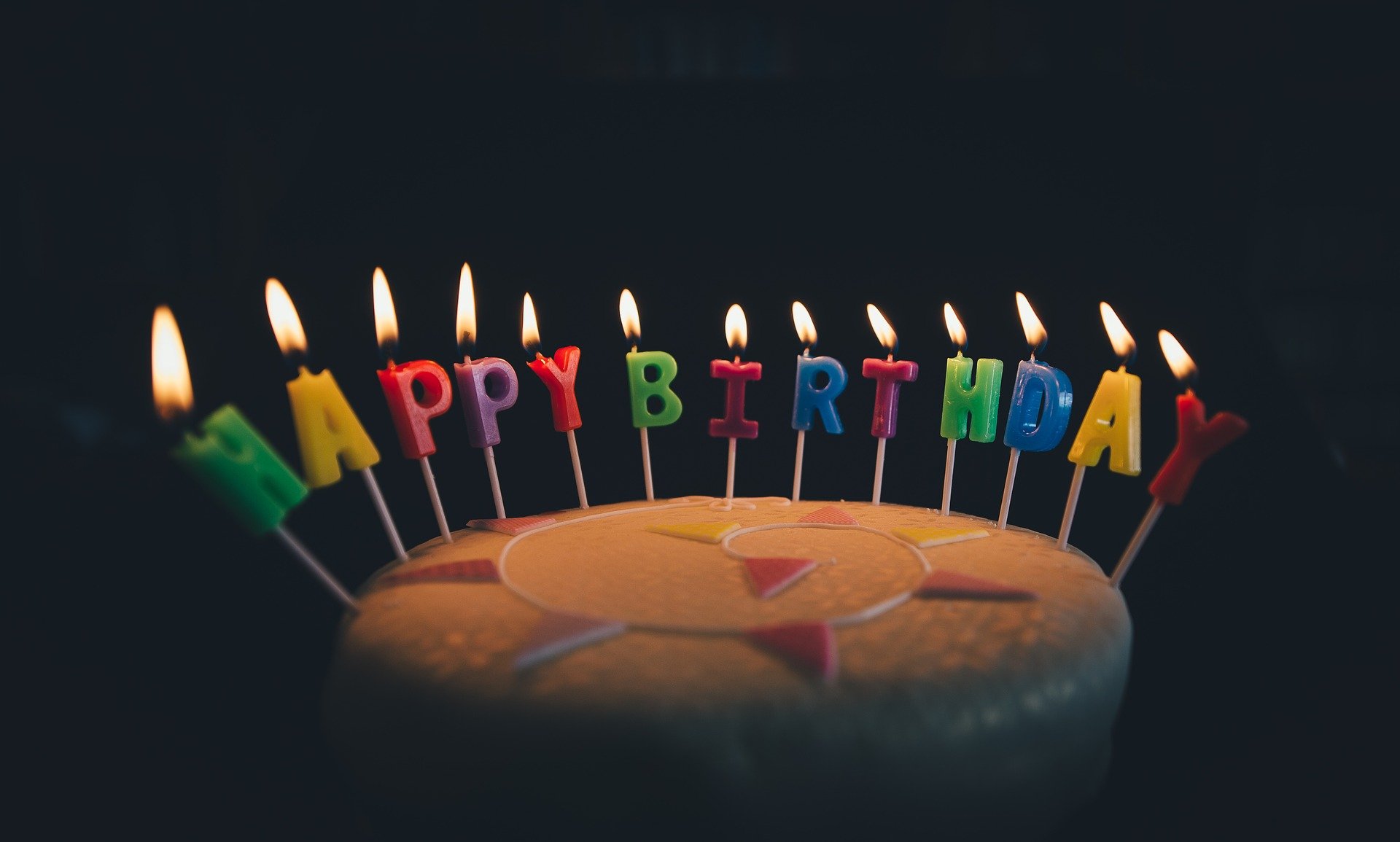 A Birthday cake with lit candles. | Source: Pixabay.