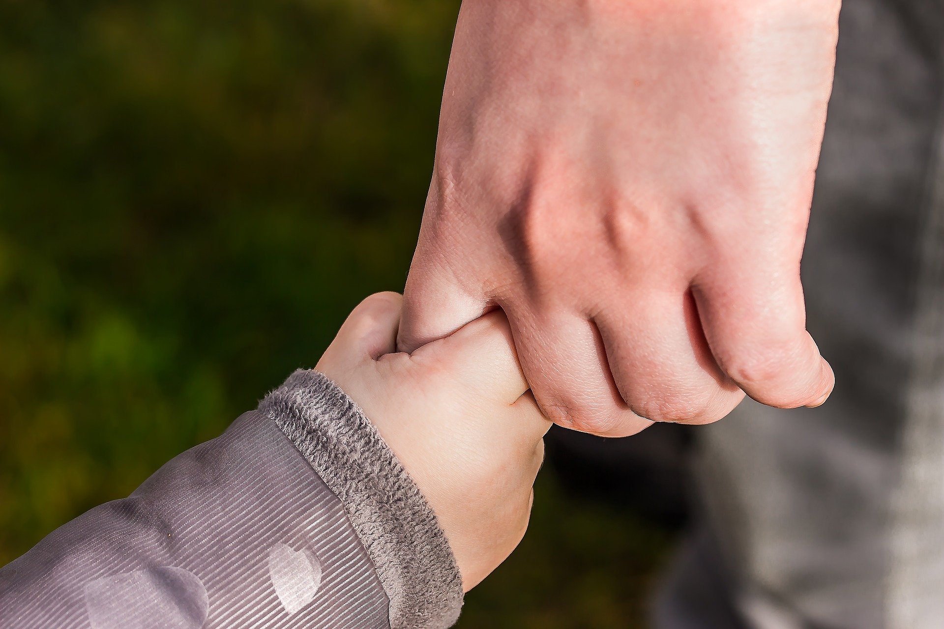 Die Hand des Erwachsenen hält die Hand des Kindes. | Quelle: Pixabay