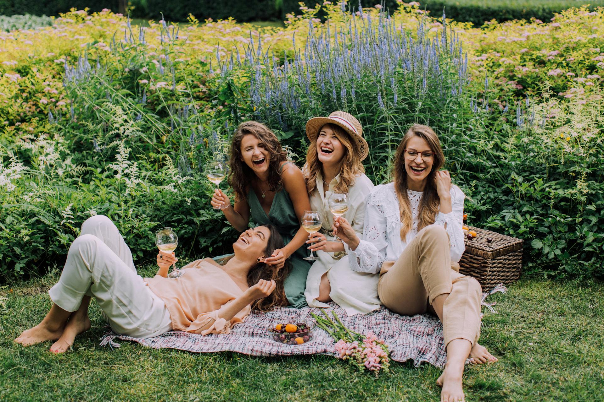 Women sitting on the grass and enjoying their drinks | Source: Pexels