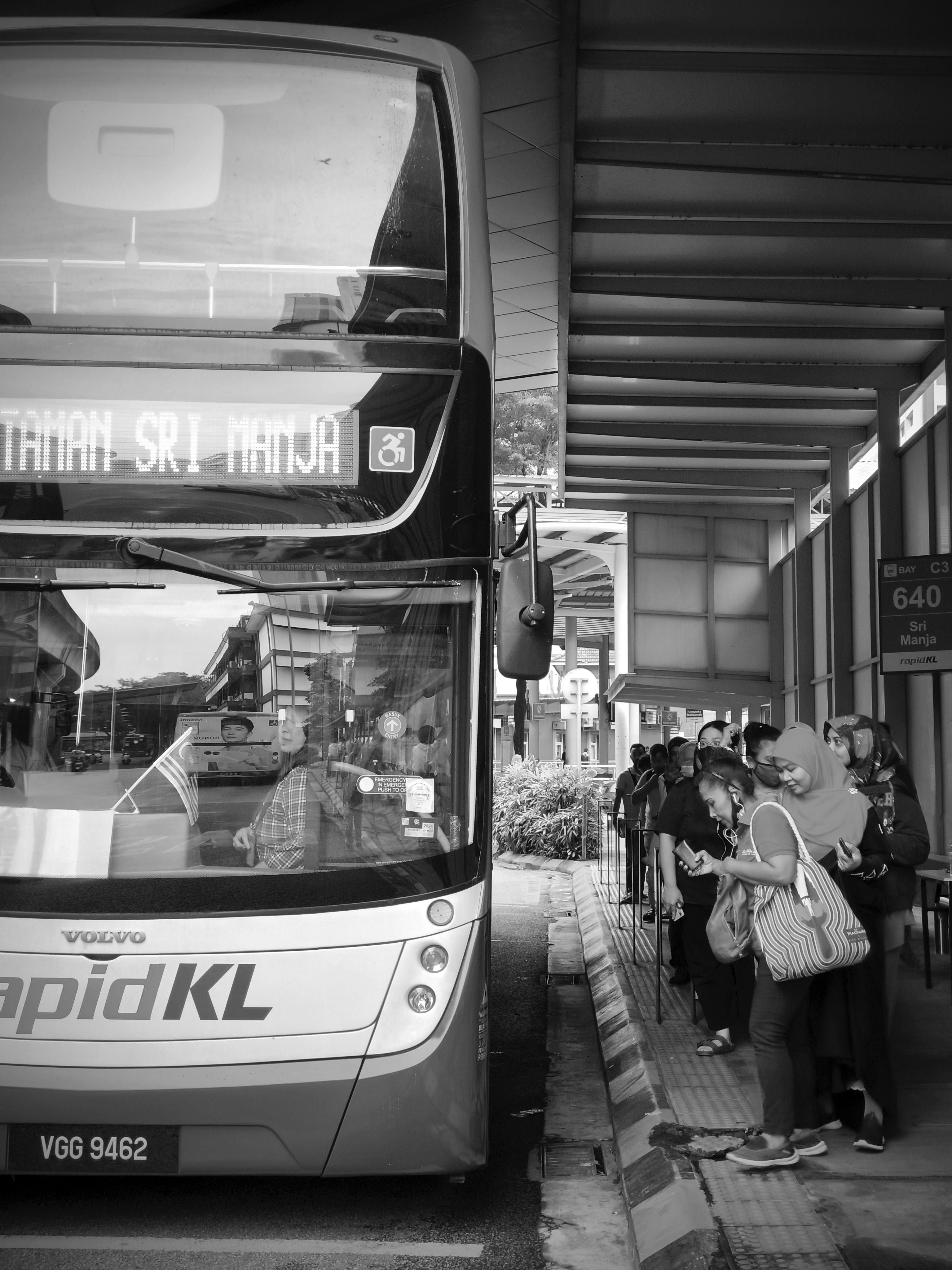 People standing at a bus station. | Source: Pexels
