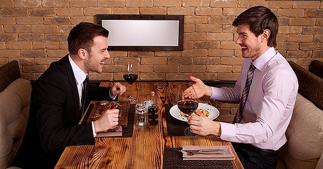 Two friends at a dinner enjoying a nice meal while having a conversation | Photo: Shutterstock