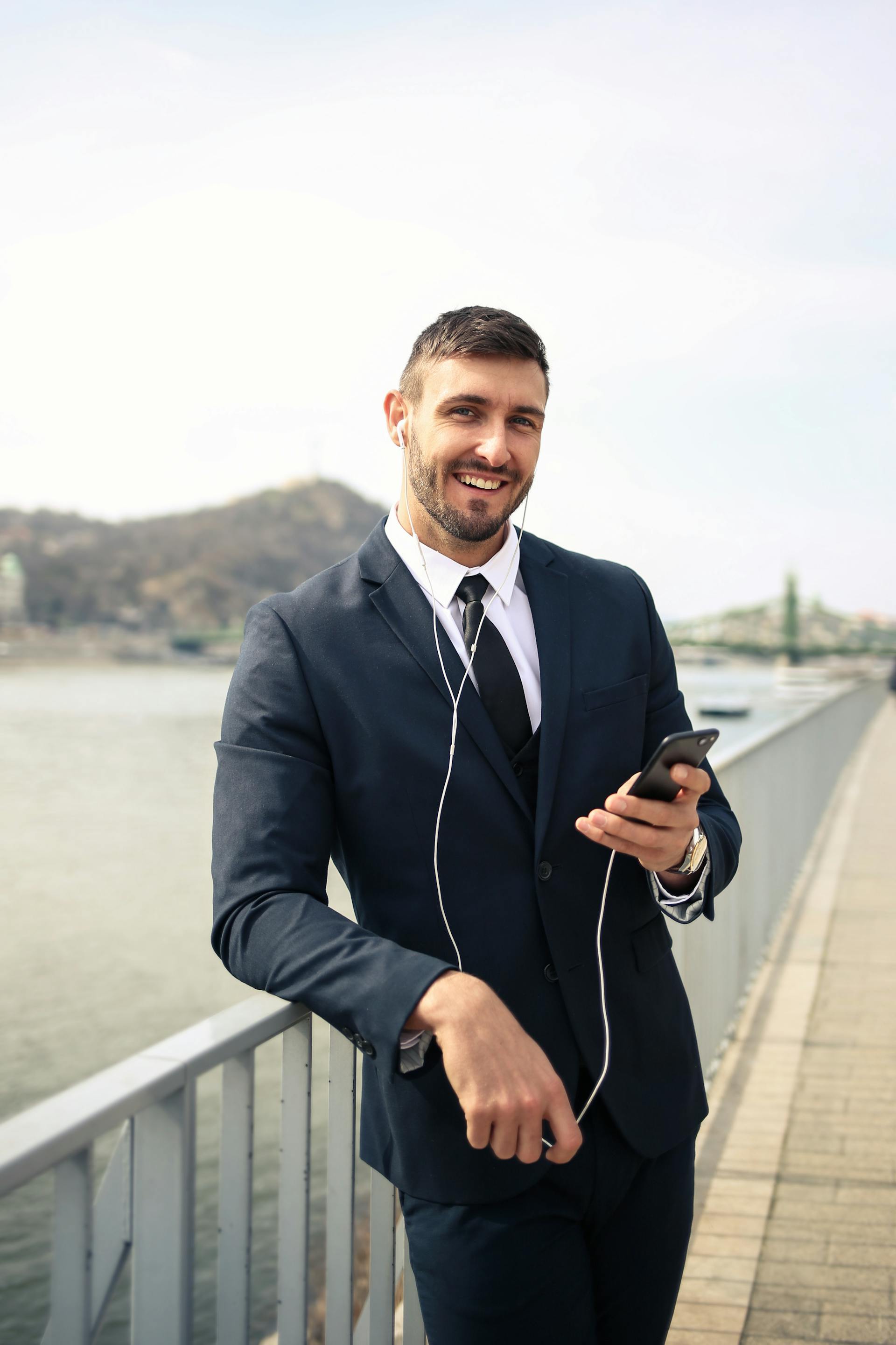 A cheerful man holding a smartphone | Source: Pexels