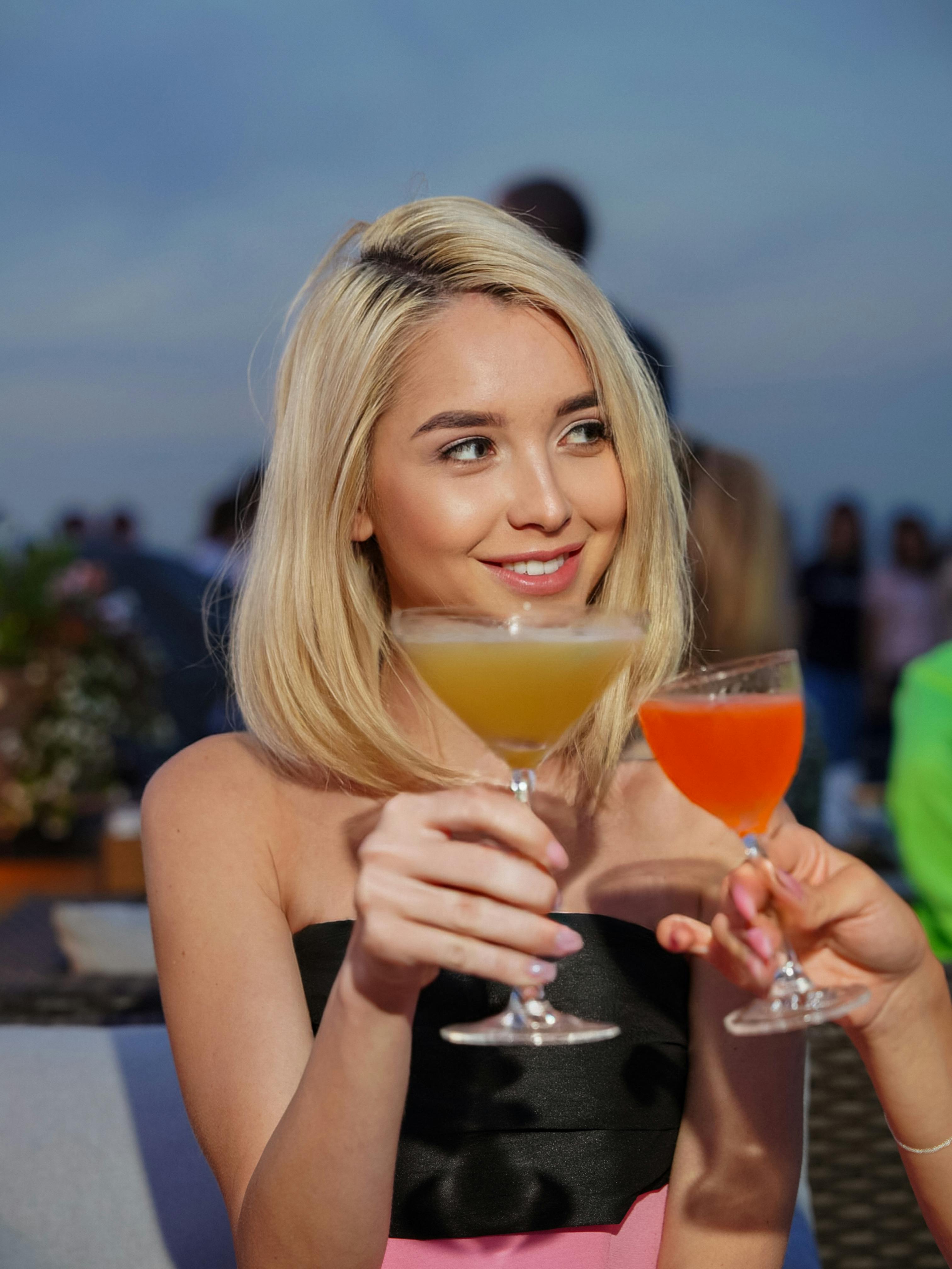 Blonde with a cocktail during a toast | Source: Pexels