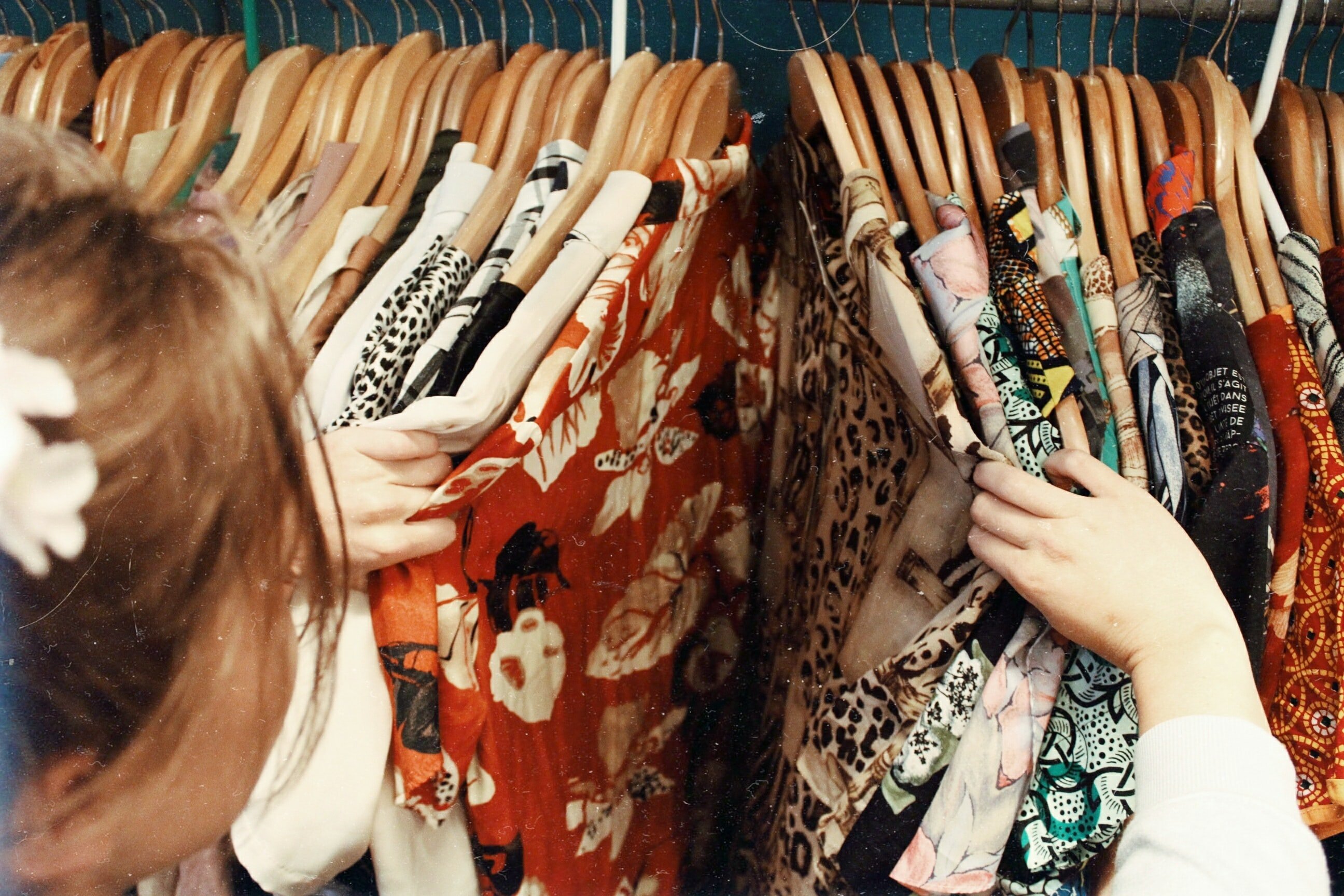 A woman looking through clothes displayed in hangers | Source: Unsplash