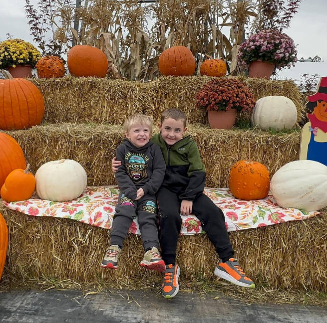 Mason and Jack Bafus posing at a fall-themed area, from a post dated November 1, 2025 | Source: Instagram/bafusfamily.duchenne