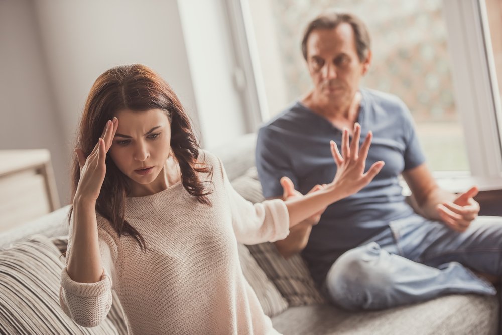 Pareja adulta peleando mientras están sentados en el sofá. | Foto: Shutterstock