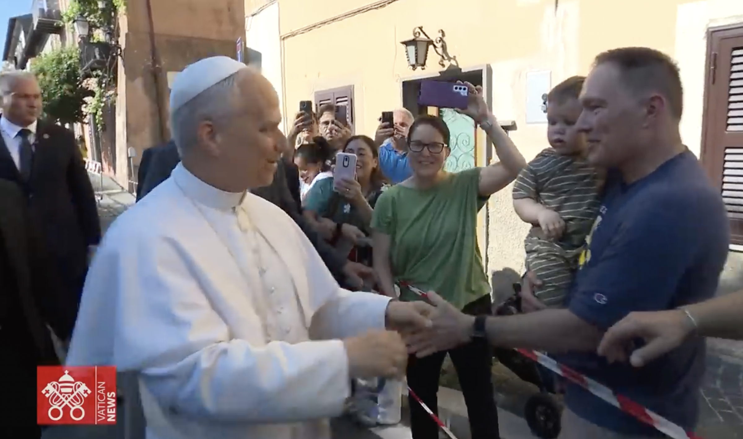 Pope Leo XIV shakes a supporter's hand at Castel Gandolfo, dated July 2025 | Source: YouTube/VaticanNews