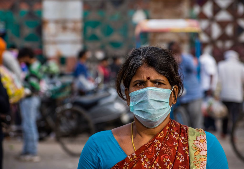 Una mujer india que se cubre la cara con una máscara camina en un abarrotado Mandi (mercado), mientras el encierro en todo el país continúa por un coronavirus novedoso altamente contagioso el 26 de marzo de 2020 en Nueva Delhi, India. | Foto: Getty Images