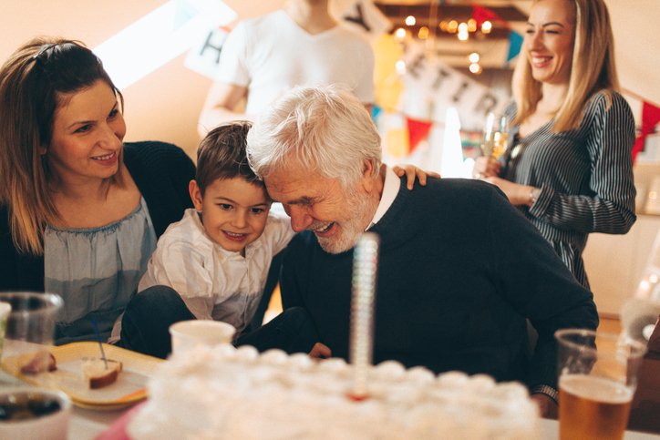Abuelo recibiendo abrazo de su nieto por su cumpleaños.| Foto: Getty Images