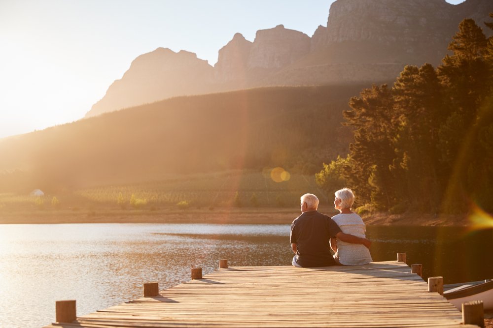 Pareja de ancianos sentadas frente a un lago.| Foto: Shutterstock