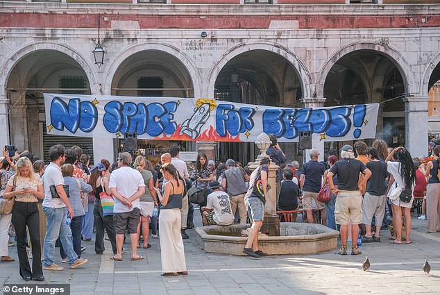 Impassioned signs reading 'No space for Bezos' and 'Veniceland: A playground fit for an oligarch' have been plastered across Venice (pictured: protestors gathered in Campo San Giacomo di Rialto)