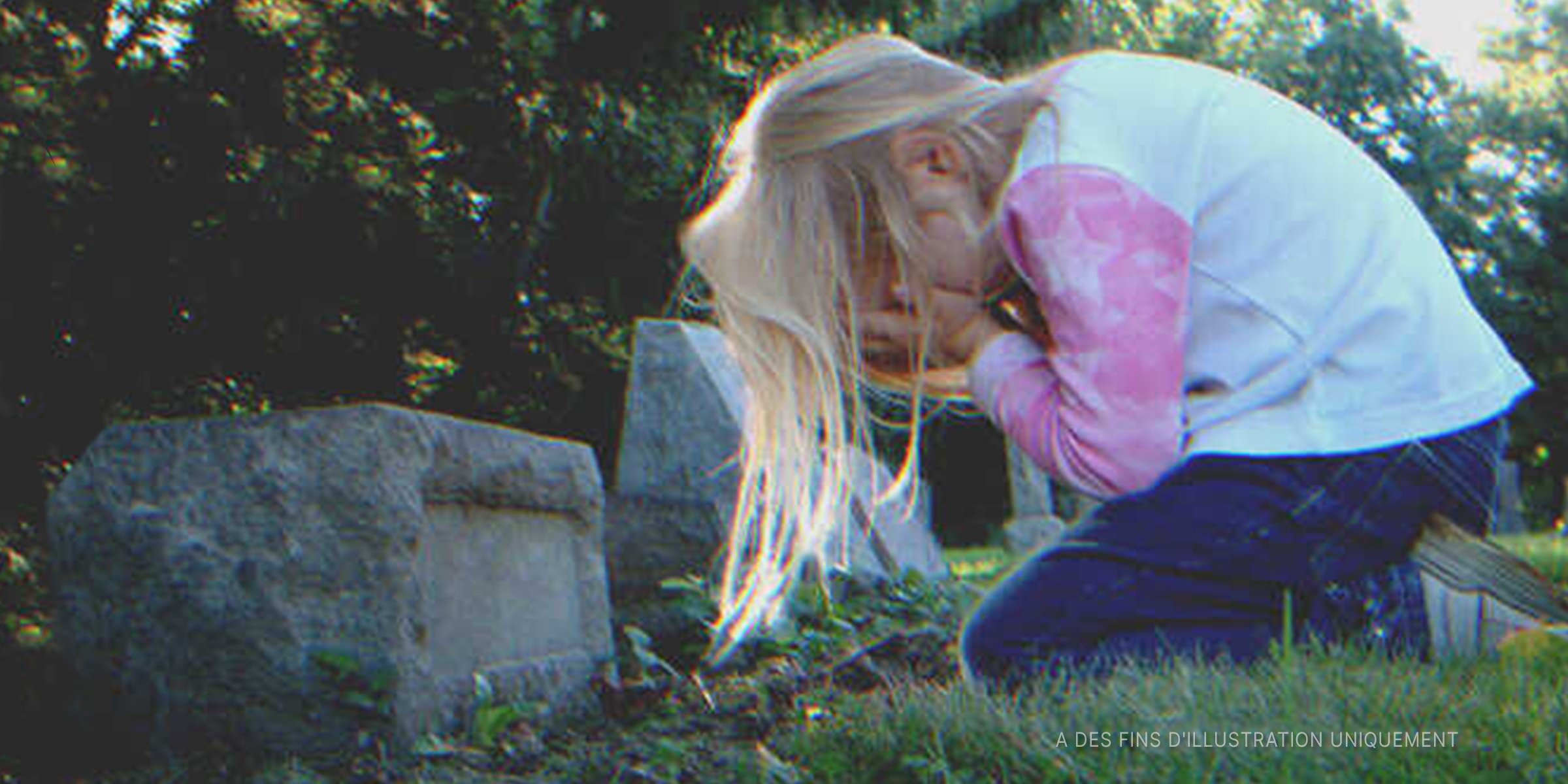 Une enfant pleurant sur une tombe | Photo : Shutterstock
