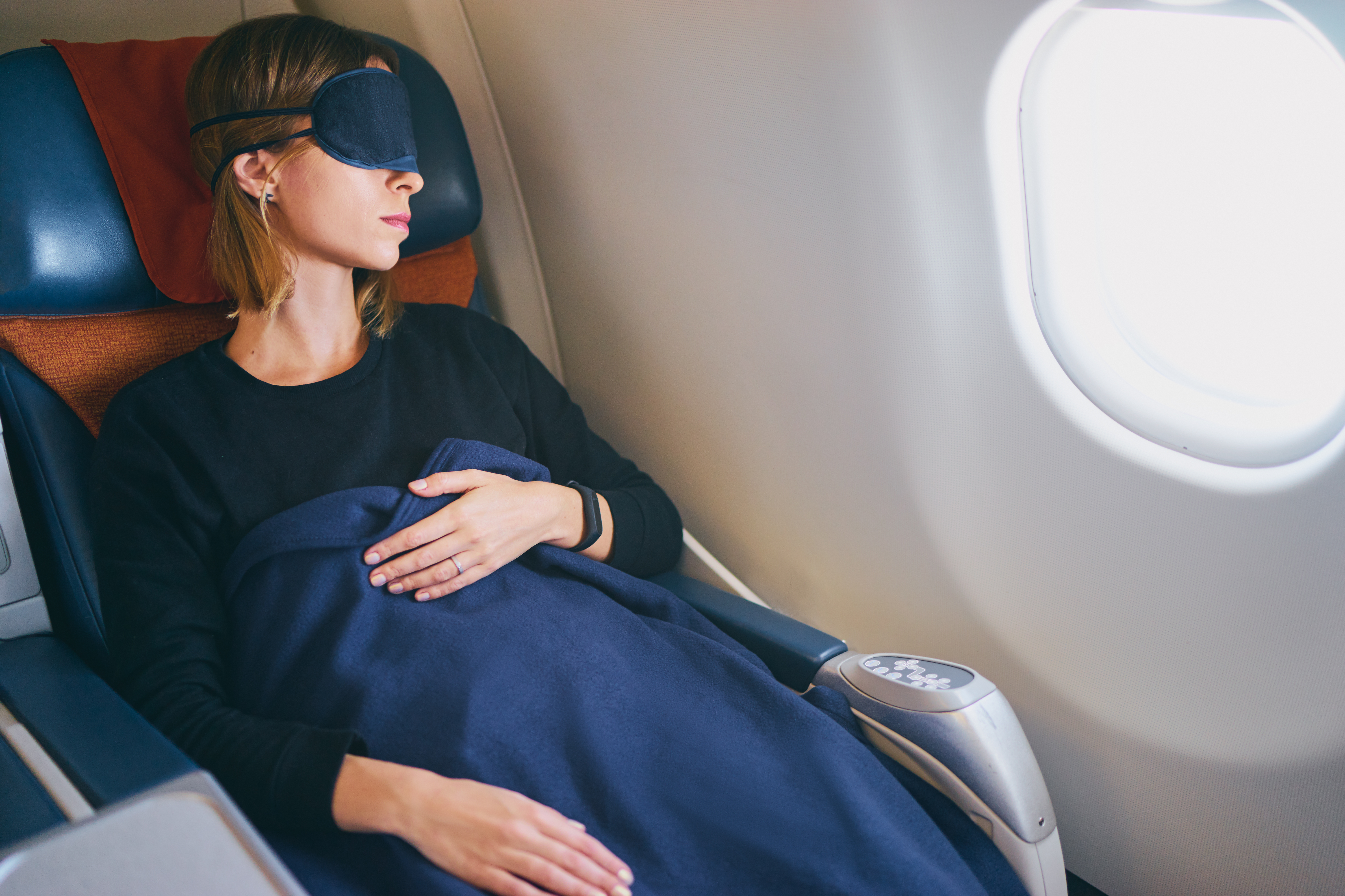 A sleeping female passenger on a plane | Source: Shutterstock