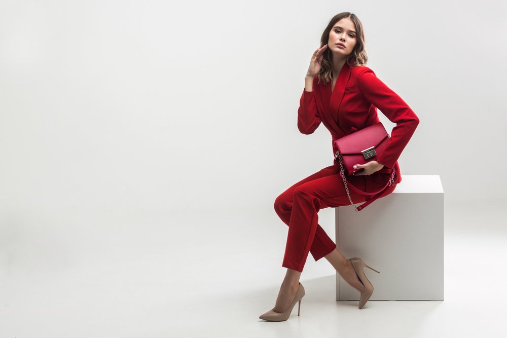 Mujer usando un blazer de color rojo combinado con pantalón y elegante bolso rojo y zapatos color nude. | Foto: Shutterstock Mujer usando un blazer de color rojo combinado con pantalón y elegante bolso rojo y zapatos color nude. | Foto: Shutterstock