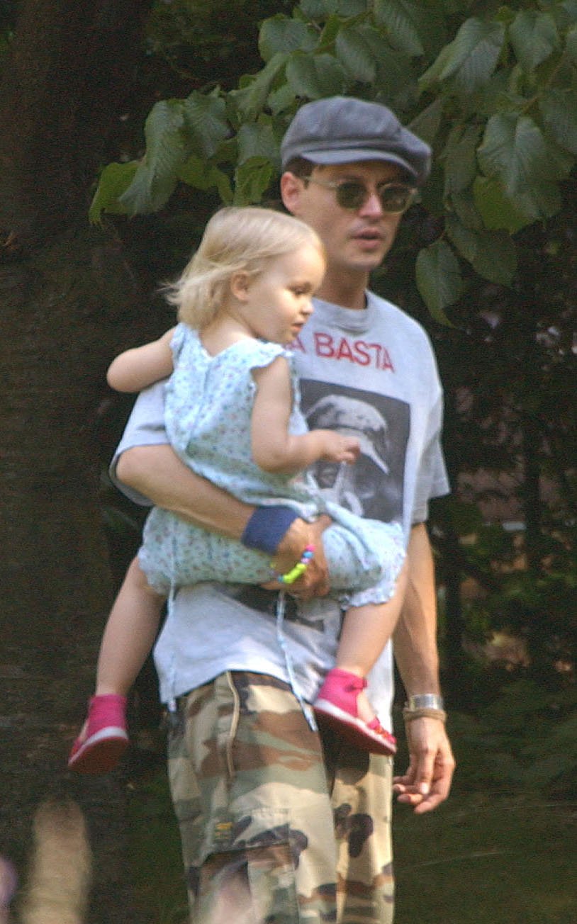 Johnny Depp con su hija, durante un picnic en un parque de Londres, el 14 de julio de 2002. | Foto: Getty Images