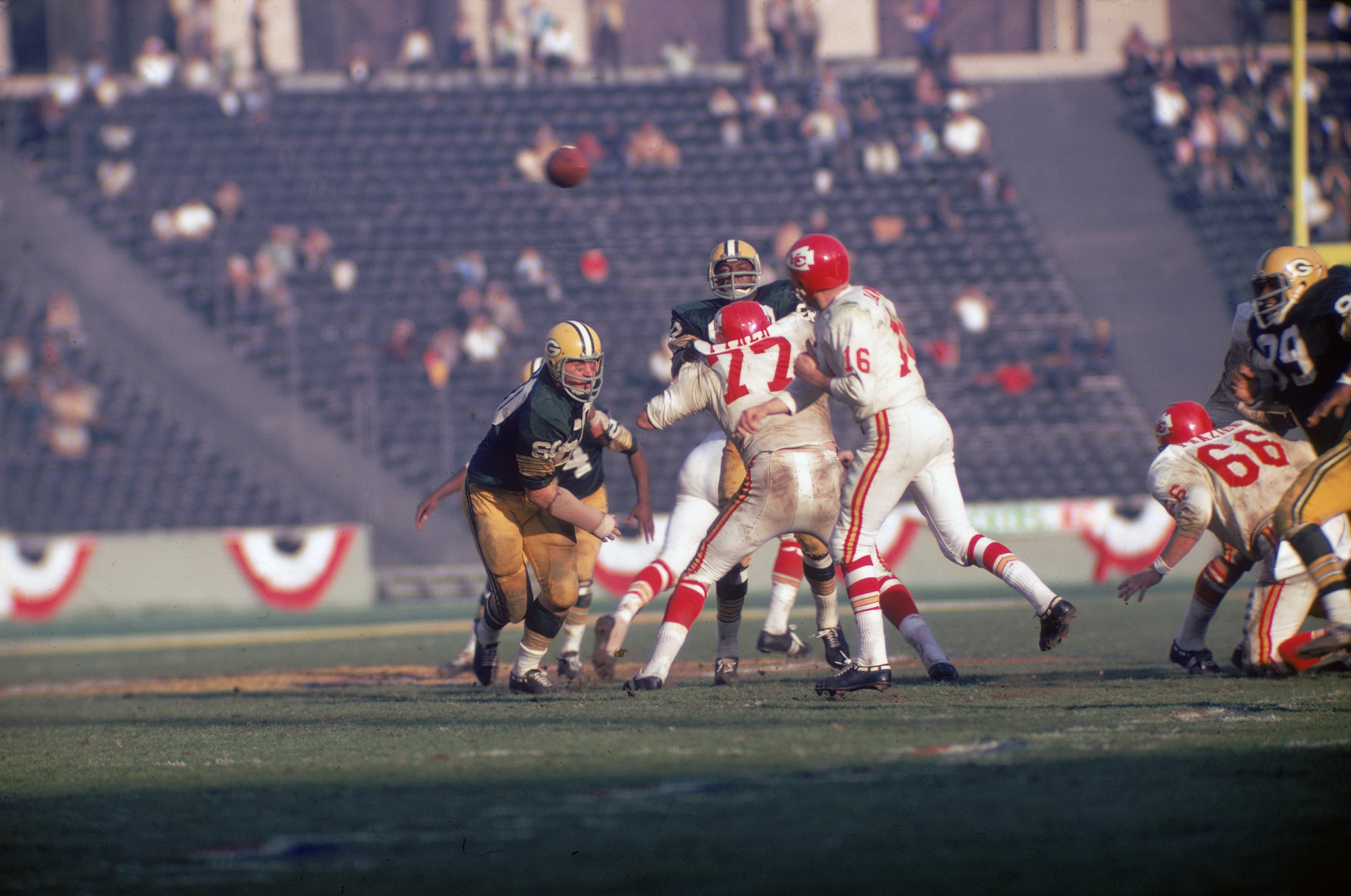 Football player Len Dawson (center, #16 in white), quarterback for the Kansas City Chiefs, throws the ball as opponent Lee Roy Coffey (left, #80) closes in during the Super Bowl, Los Angeles, California, January 15, 1967 | Photo: Getty Images