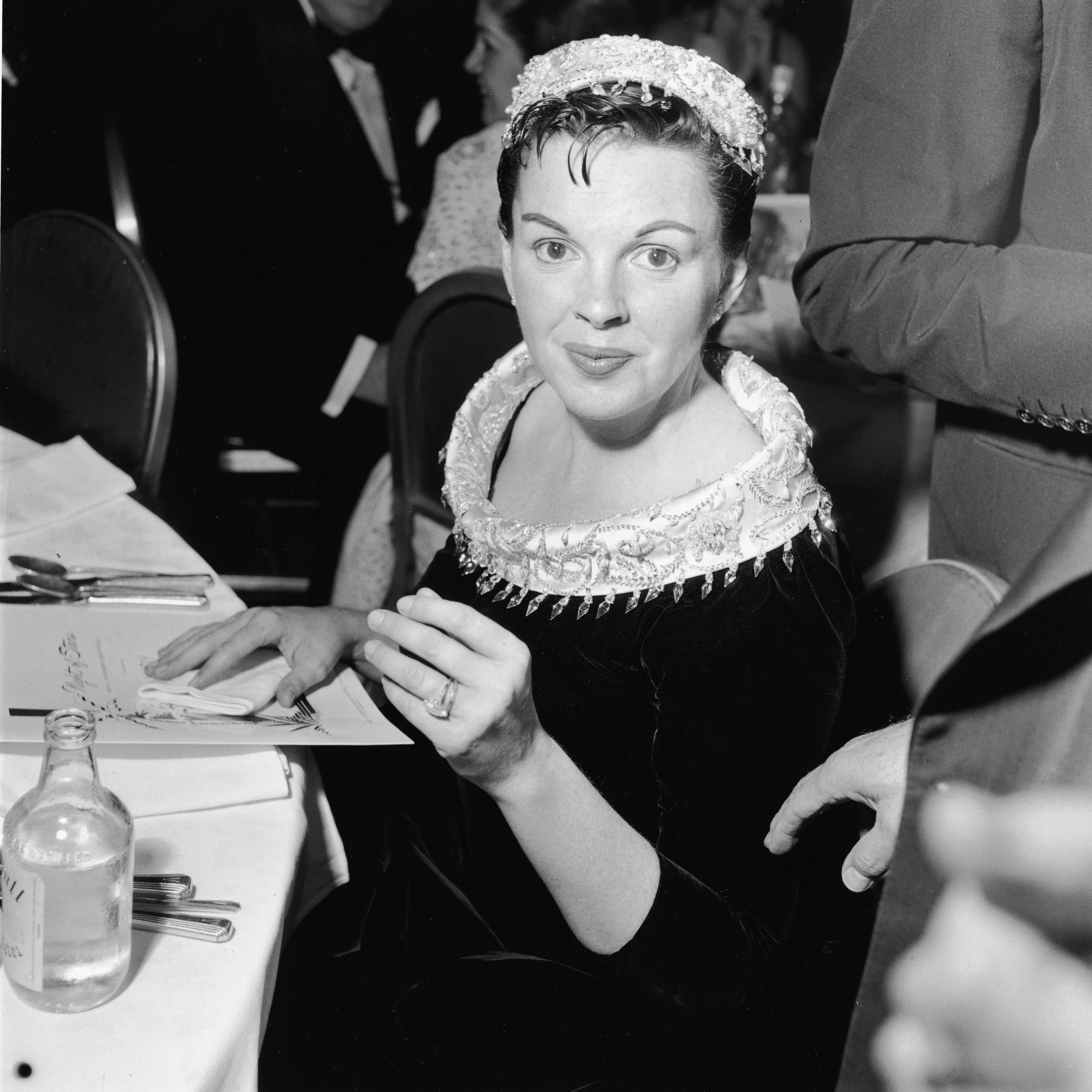 Judy Garland (1922 - 1969) sits at a table at the premiere of the film "A Star Is Born." | Source: Getty Images