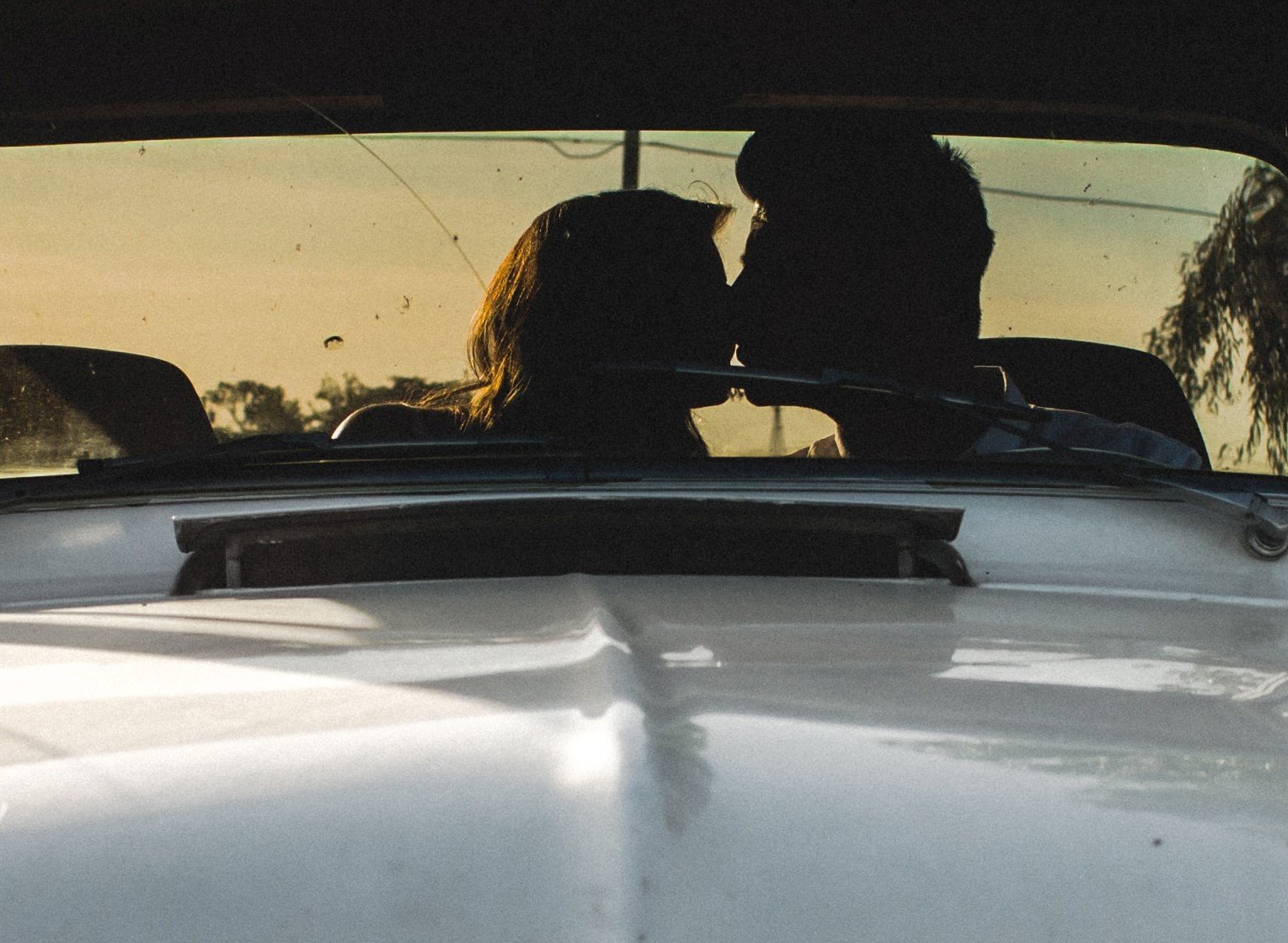 Una pareja besándose en un automóvil. | Foto: Unsplash