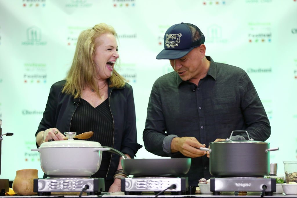 Michael Symon and Liz Symon participate in a cooking demo. | Source: Getty Images