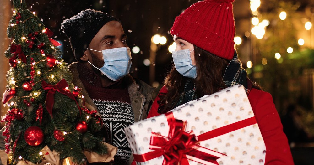 Pareja con mascarillas a punto de abrir los regalos. | Foto: Shutterstock