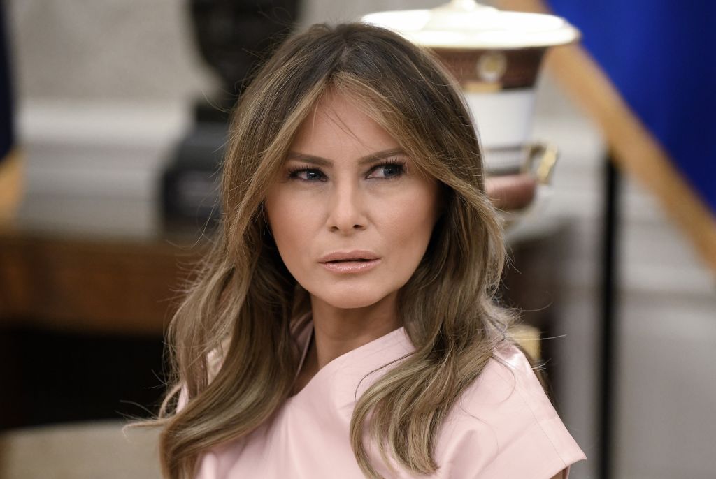 A side profile captures Melania Trump's layered highlights and softly styled hair. The close-up angle emphasizes her eyes, cheekbones, and polished appearance.