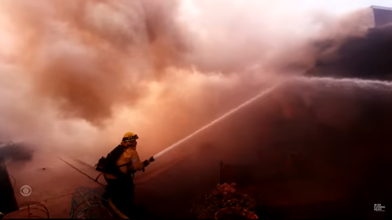 A firefighter attempting to douse a wildfire in Los Angeles, California on January 7, 2025. | Source: YouTube/CBSEveningNews