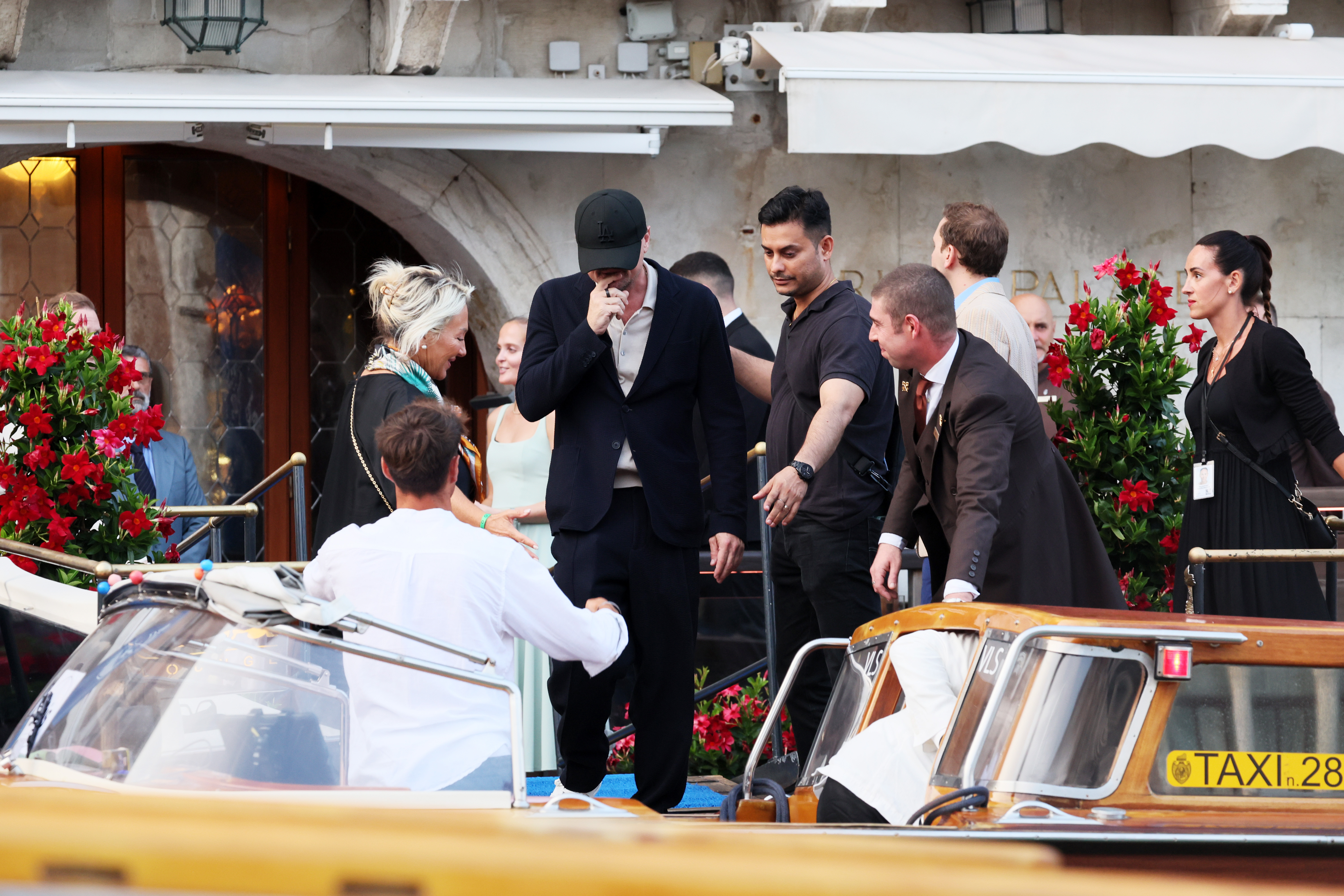 Leonardo di Caprio is seen as he is about to enter the taxi boat that conveys the celebrities to the A-list wedding in Venice, Italy. He is dressed in a greyish shirt tucked under a black jacket and trousers. He finishes his look with a face cap that hides his face from the camera.