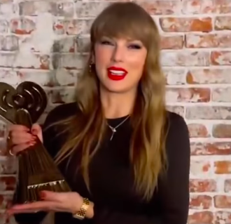 Taylor Swift holding her award. | Source: Instagram/iheartradioau