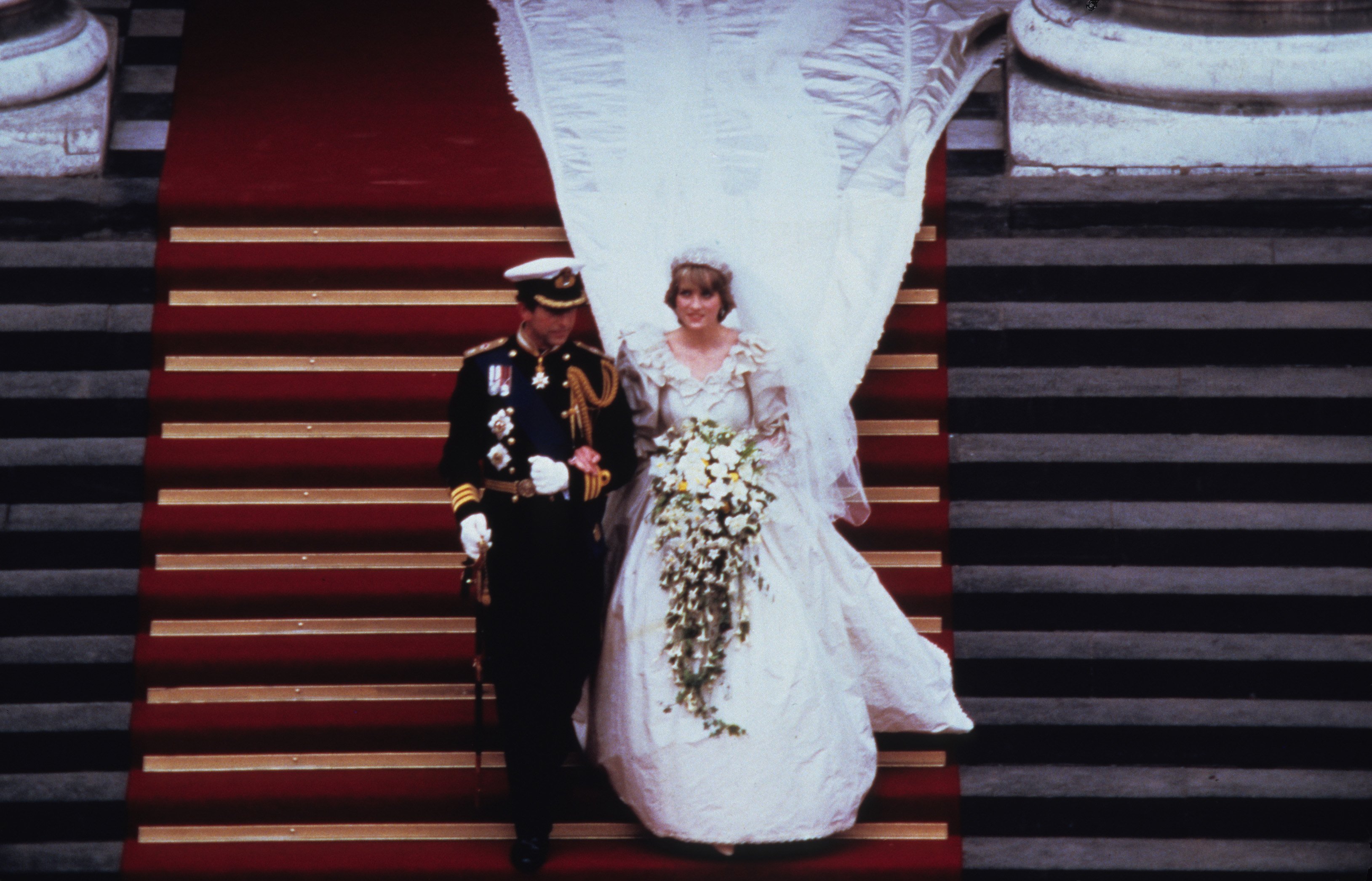 Prince Charles,  and Diana,  wearing a wedding dress designed by David and Elizabeth Emanuel and the Spencer family Tiara, leave St. Paul's Cathedral following their wedding on July 29, 1981 in London, England. | Source: Getty Images