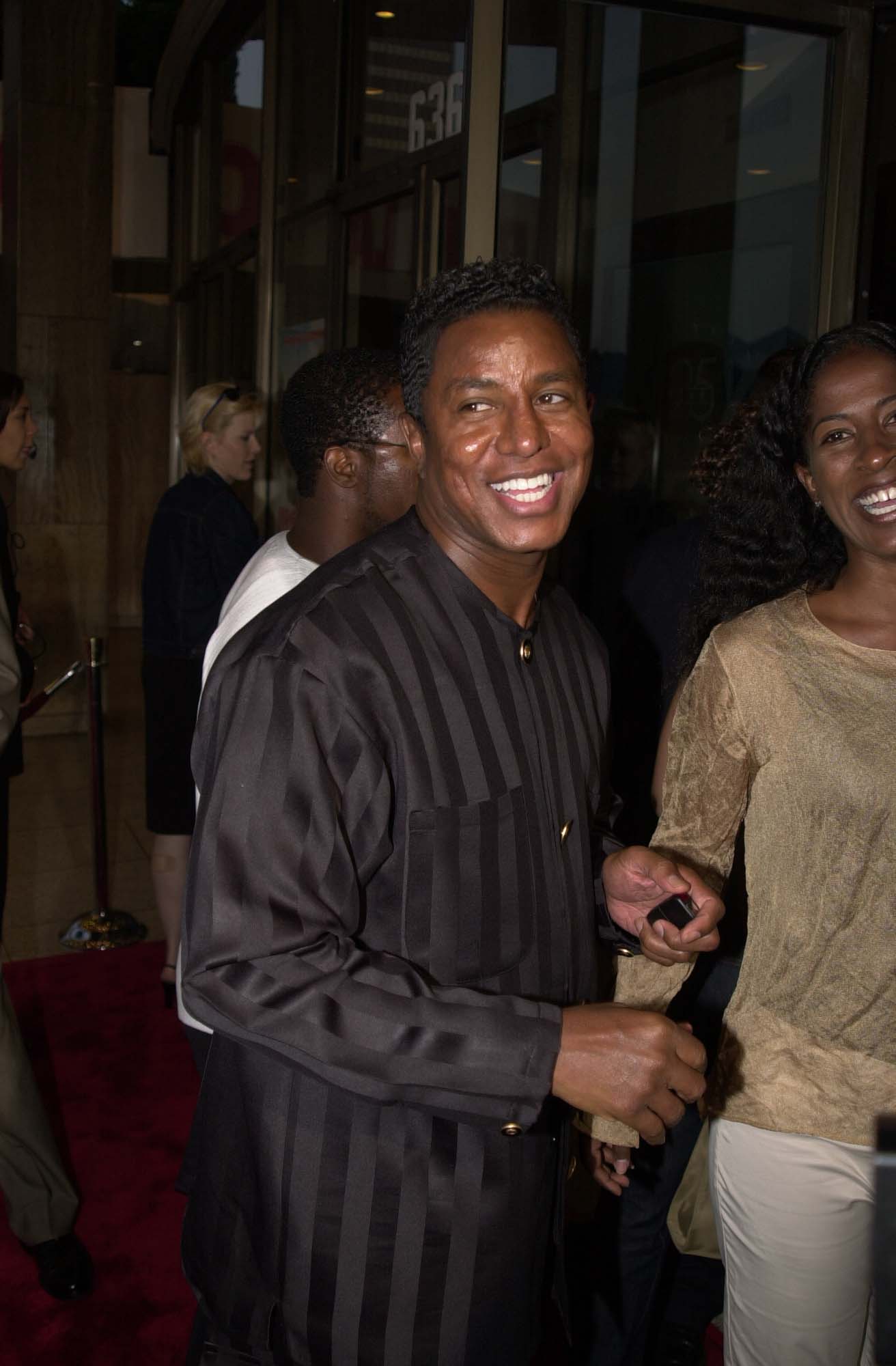 Jermaine Jackson smiles broadly on the red carpet at the Big Momma’s House premiere, wearing a sleek, striped ensemble that adds subtle flair. Caught mid-laugh, the candid moment highlights his easy charisma and comfort in the spotlight.