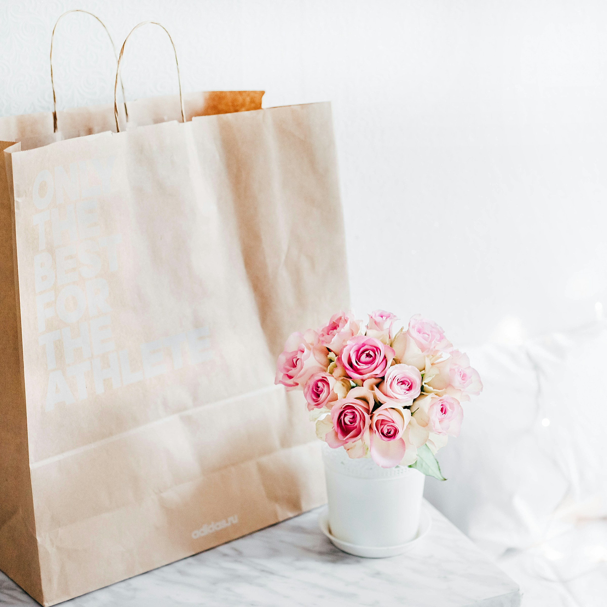 A bouquet of pink roses and a brown bag | Source: Unsplash