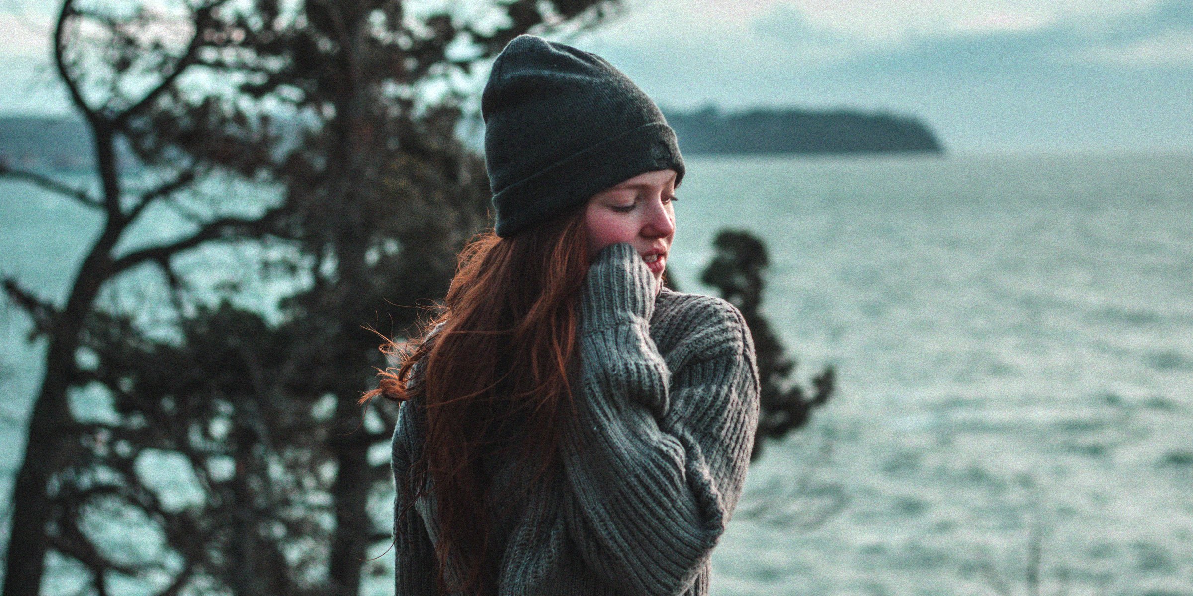 Unsplash | A girl looking sideways with her hand on her face.