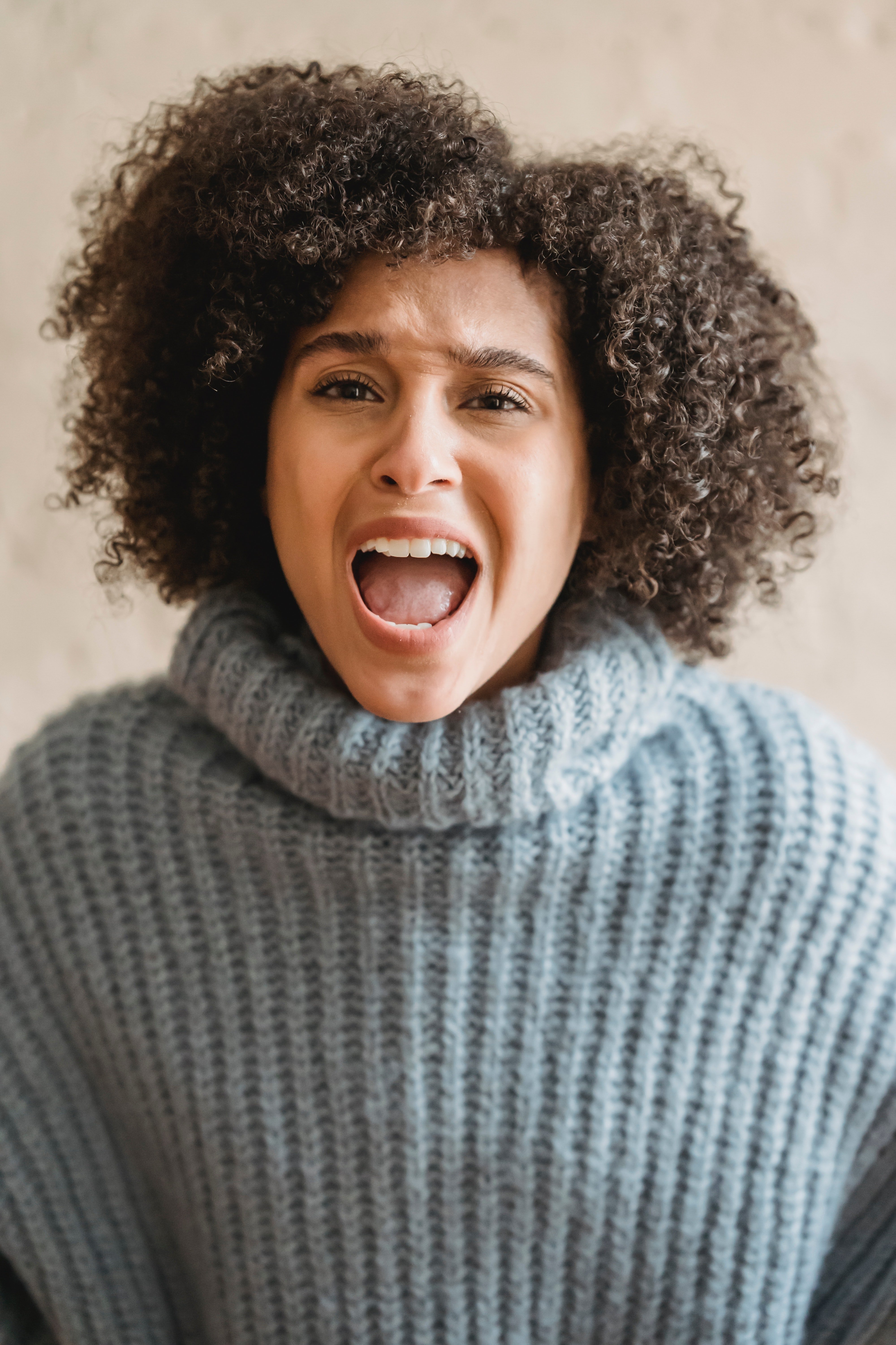 Woman in a gray knit sweater yelling | Source: Pexels