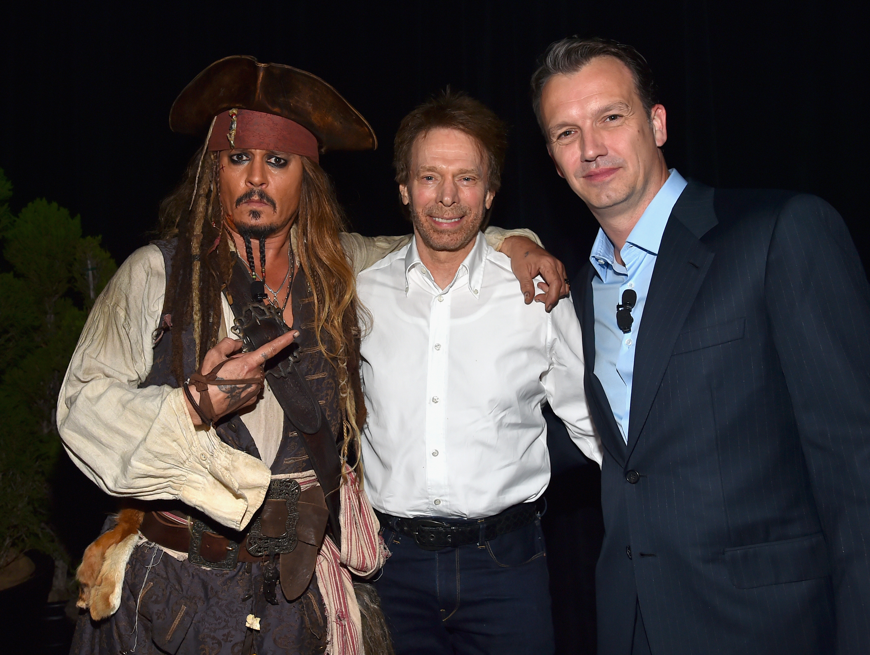 Johnny Depp, as Captain Jack Sparrow, with Jerry Bruckheimer and Sean Bailey at the "Worlds, Galaxies, and Universes: Live Action at The Walt Disney Studios" presentation at Disney's D23 EXPO in Anaheim, California, on August 15, 2015 | Source: Getty Images