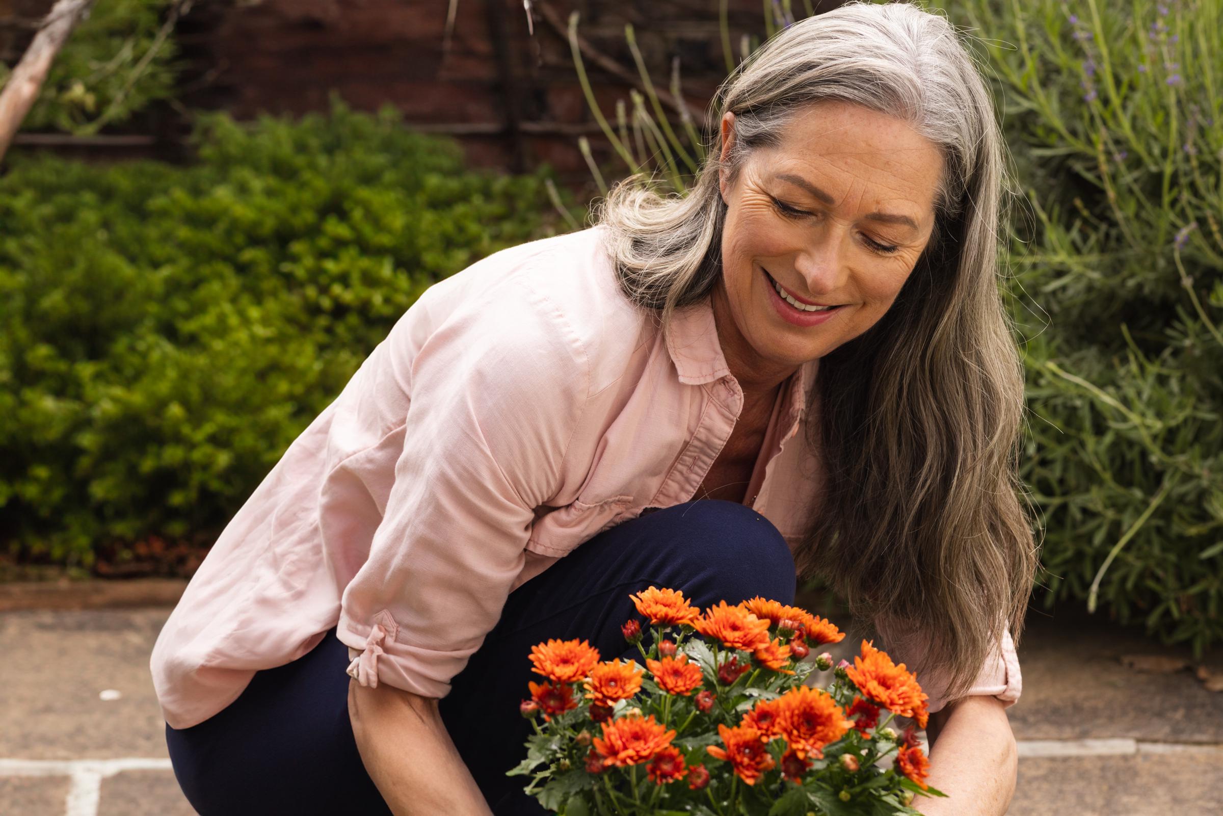 Woman planting flowers in the garden | Source: Shutterstock